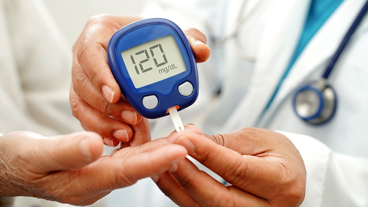 The Asian doctor who uses the glucose digital meter to check the blood sugar level to the treatment of diabetes.
