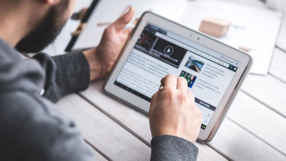 A man who reads an article on his tablet.