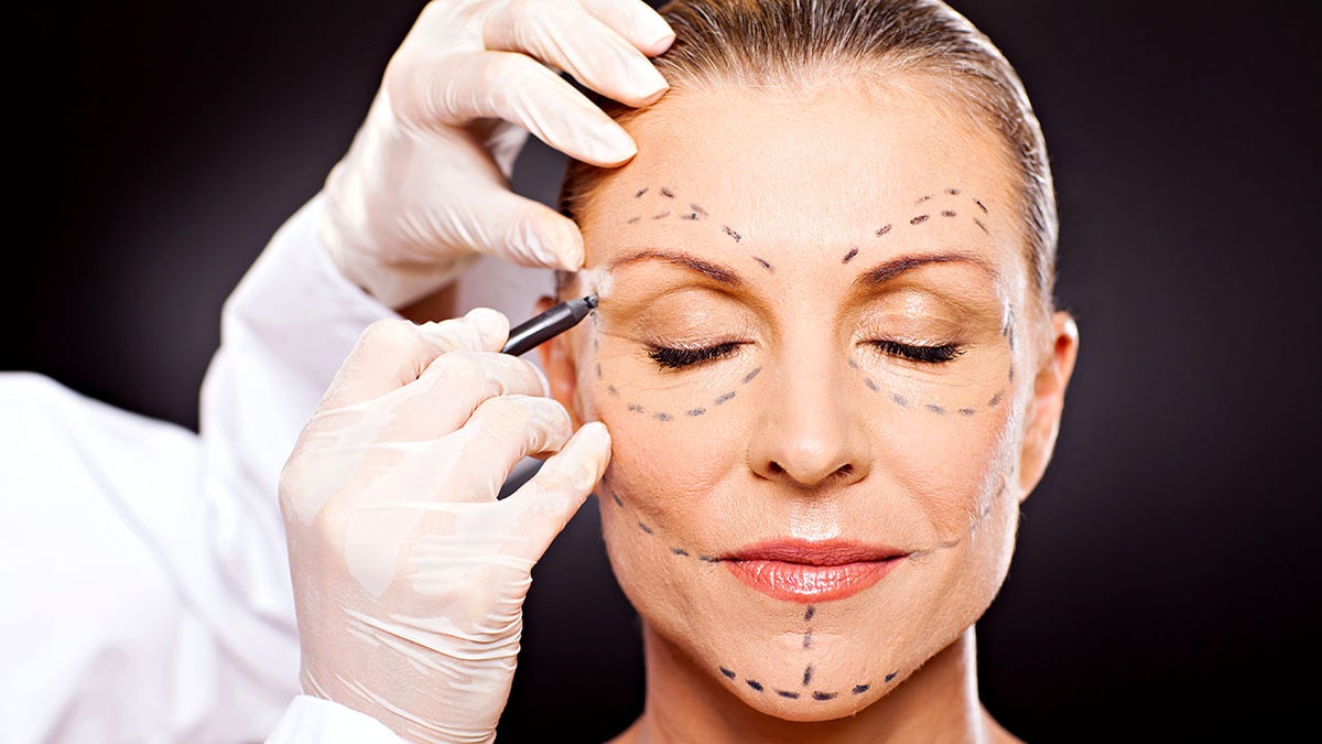 Women of Middle Ages with correction marks that are prepared for plastic surgery